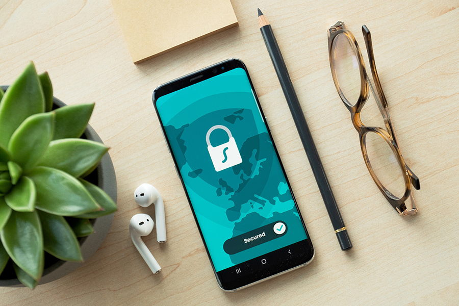 Sicherheits-App auf Smartphone mit Schreibtisch-Accessoires