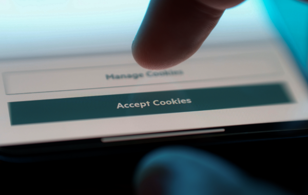 Finger tippt auf „Accept Cookies“-Button auf Smartphone-Bildschirm zur Zustimmung von Website-Cookies.