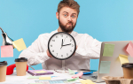 Mann im Büro mit einer großen Uhr in der Hand