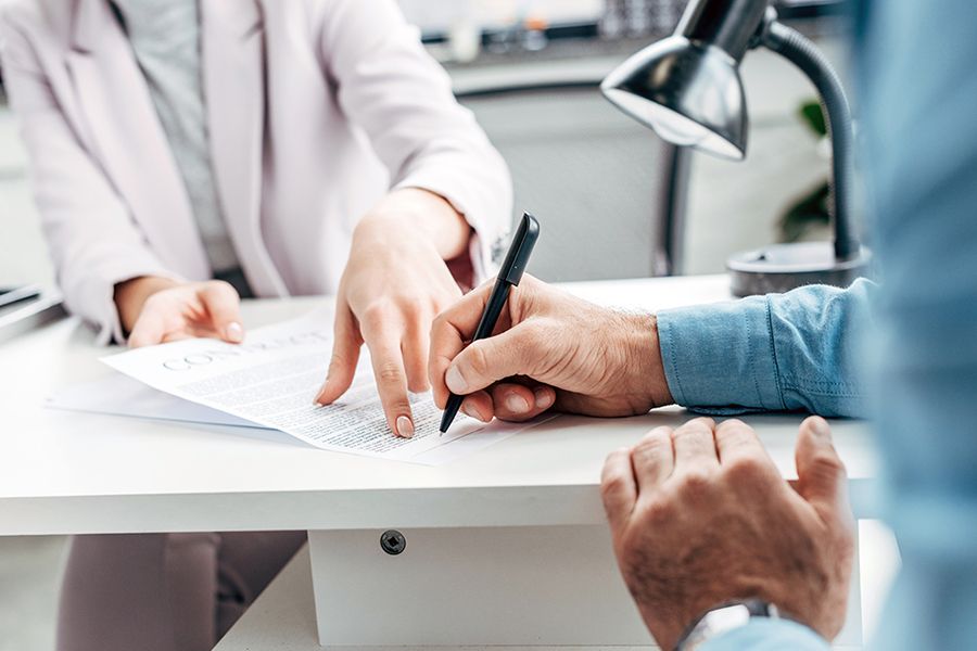 Unterzeichnung eines Vertragsdokuments am Schreibtisch