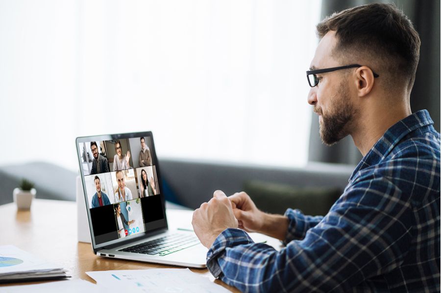 Man sitzt vor Notebook in einem online Meeting